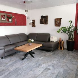 Wohnzimmer mit grauer Couch und Holztisch